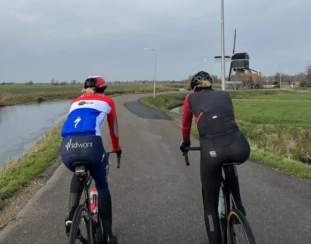 Demi Vollering and friend riding bikes on a road